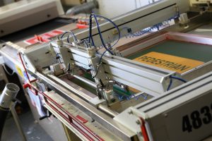 a screen printing machine in use printing signs