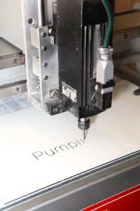 close up of an engraving machine engraving the word pumping